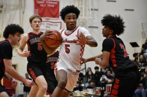 Junior Daniel Jackson Jr. holds on to the ball on his way to the hoop. Ben Ray / The Reporter