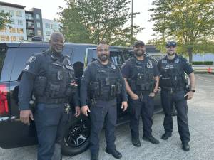 Renton Police Department officers Sgt C. Jacobs, Sgt. C. Johnson, Traffic Officer C. Catalan, and Traffic Officer M. Nugent in front of a police vehicle. Photo courtesy of Ryan Rutledge