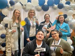 Joaquin Ken Delgado is pictured holding a Peer Support sign with other Renton Municipal Court employees. Photo courtesy of Joaquin Delgado