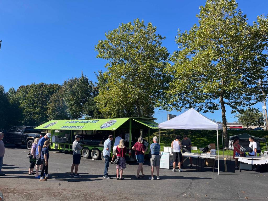 Community members line up in front of C. Davis Texas BBQ at Wednesdays fundraiser for Top of the Hill Quality Produce. (Benjamin Leung/Renton Reporter)