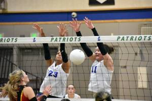 Julianne Lee (11) and Kendreah Beazer (23) combine for a block against Newport. Ben Ray / The Reporter