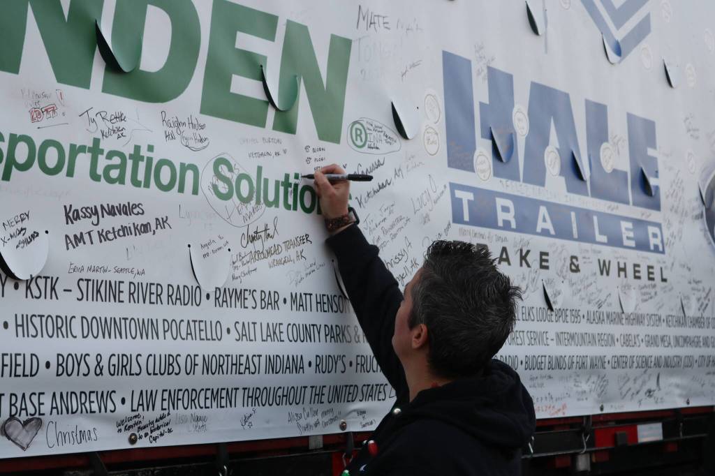 Rentonites wasted no time adding their names and messages to the side of the trailer hauling the tree. Photo by Bailey Jo Josie/Sound Publishing.
