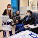 Samuel Martinez Santamaria (right) was one of the first patients to receive treatment at the new Cancer Center. He was attended by Licensed Practical Nurse (LPN) Leigha Baker (left) and supported by his husband Alex Shockey (center), who is also a Valley Medical Center employee. Photo courtesy of Valley Medical Center.