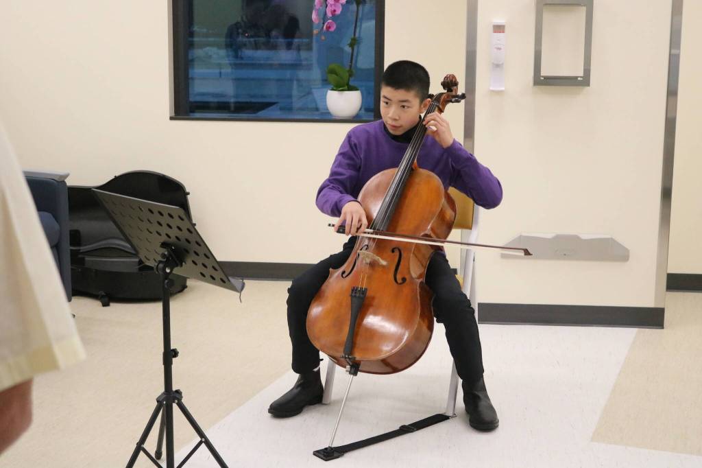A young cellist performs music in one of the Infusion bays of the new center. Photo by Bailey Jo Josie/Sound Publishing.