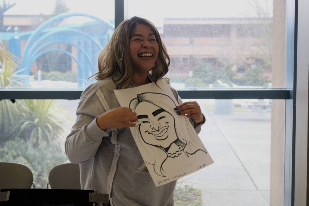 Fancy Vargas of Elevate PR holds her caricature portrait by Markas Odom, who is @brother_caricature on Instagram. Photo by Bailey Jo Josie/Sound Publishing.