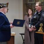 An American Legion Post 19 member presenting a certificate to Officer Blake Bowie. Photo by Joshua Solorzano/The Reporter