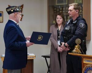 An American Legion Post 19 member presenting a certificate to Officer Blake Bowie. Photo by Joshua Solorzano/The Reporter