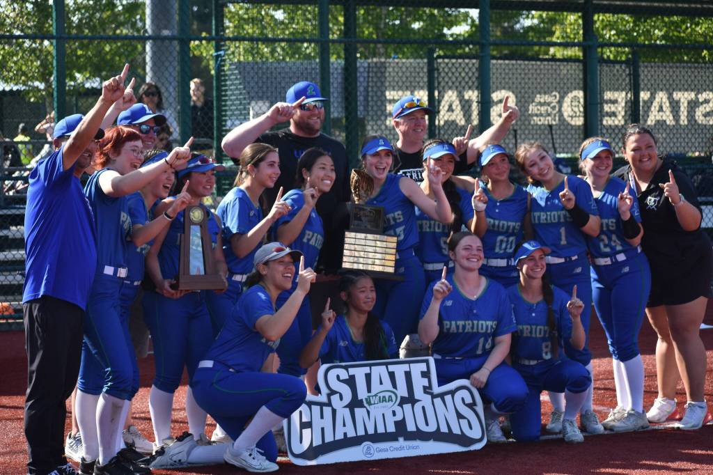 Liberty coaches and athletic director take a photo after winning the state tournament. Ben Ray / The Reporter