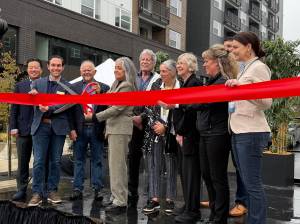 Renton City Councilmember Ruth Pérez cuts the ribbon celebrating the opening of Astra and Solera along with other councilmembers and other leaders instrumental in the opening of the apartments. Photo by Drew Dotson/Renton Reporter