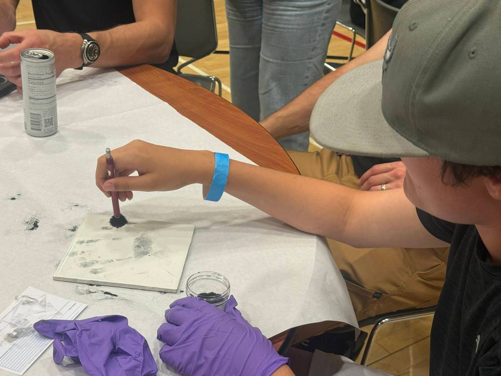 Kids do a fingerprinting activity.
