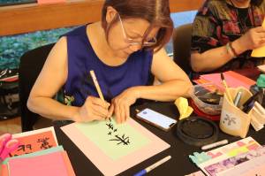 Chinese calligraphy instructors made pieces at the showcase of peoples names in Chinese characters. Photo by Bailey Jo Josie/Sound Publishing