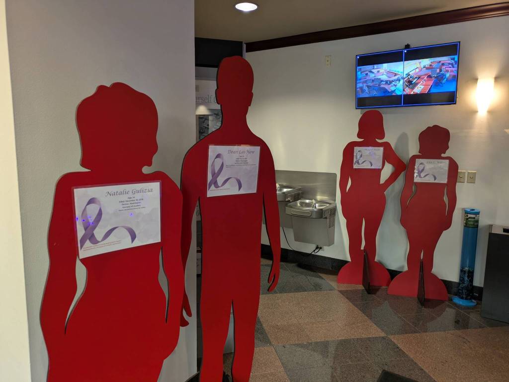 Silhouettes fill the lobby of Renton City Hall, telling the stories of Renton residents who have lost their lives due to domestic violence.
