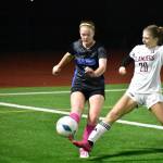 Katie Christianson looks to clear a ball over the outstreched foot of Hayden Feimster. Ben Ray / The Reporter