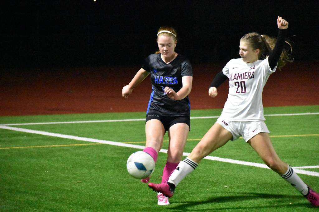 Katie Christianson looks to clear a ball over the outstreched foot of Hayden Feimster. Ben Ray / The Reporter