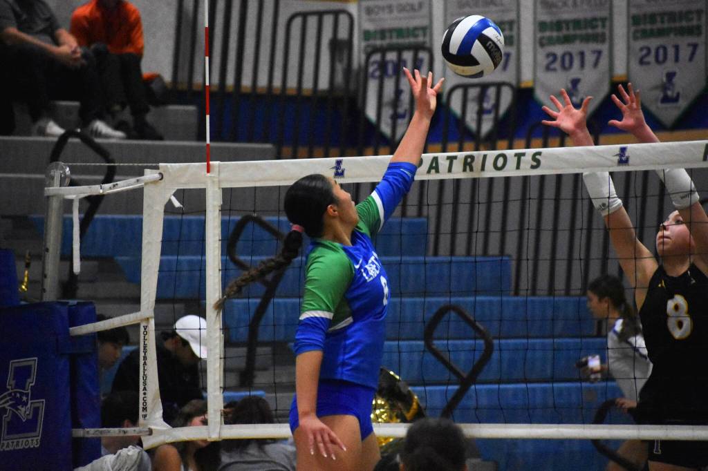 Charlize Espinosa goes for the ball at the net for Liberty against Issaquah. Ben Ray / The Reporter