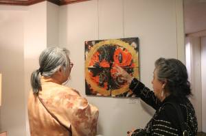 Chiho Sanada talks with a guest about one of her pieces. Photo by Bailey Jo Josie/Sound Publishing