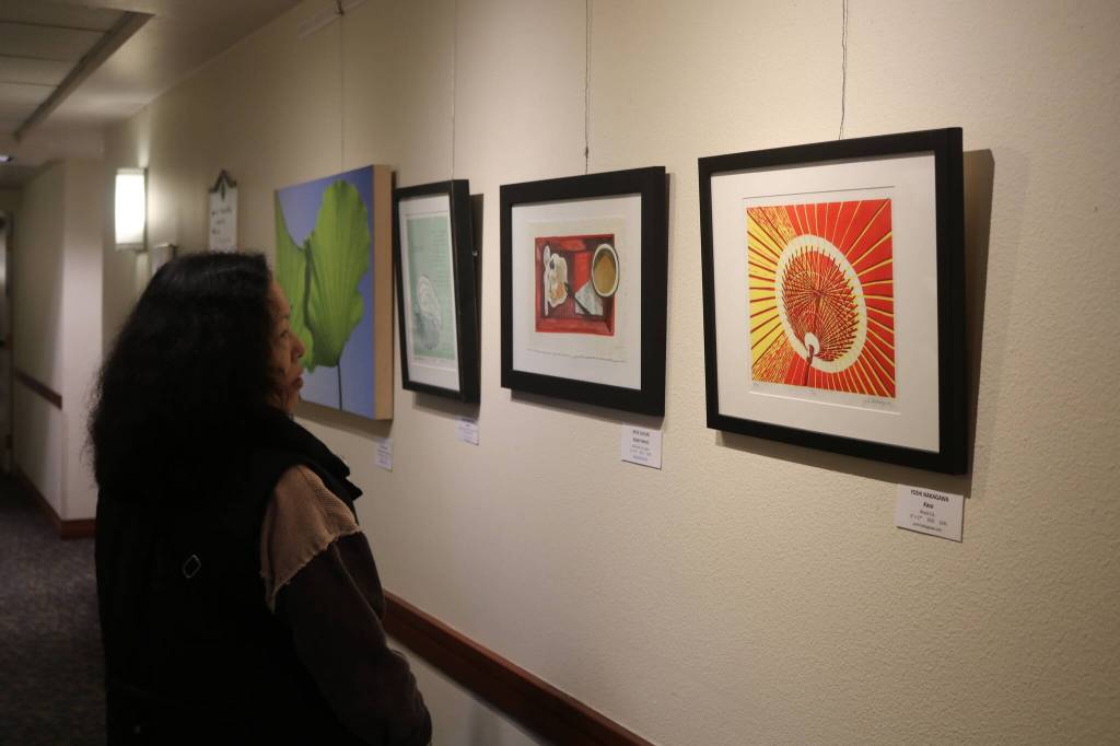 A guest to the gallery opening looks at Yoshi Nakagawas Kasa piece. Photo by Bailey Jo Josie/Sound Publishing
