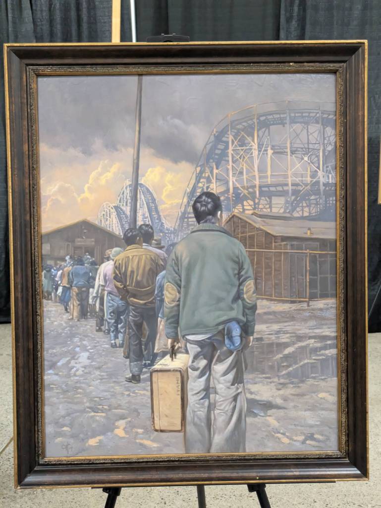Photo by Bailey Jo Josie/Sound Publishing
A painting by Chris Hopkins explores the incarceration experience, this one highlighting the stark contrast of the use of the Washington State Fairgrounds for imprisoning Japanese American families with its other uses for entertainment as a rollercoaster looms above those entering the Puyallup Assembly Center.