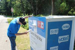 A man places his ballot into the drop box outside Federal Way City Hall. Bailey Jo Josie/Sound Publishing