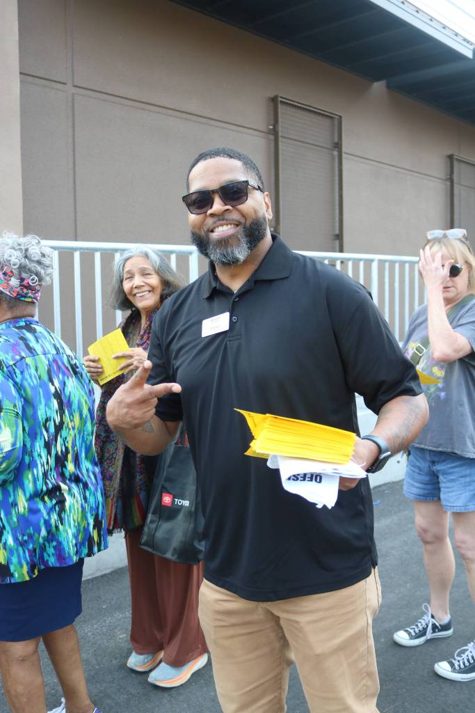 WinCos Shawn hands out small aisle maps for customers as they waited to get into the new WinCo. Photo by Bailey Jo Josie/Sound Publishing.